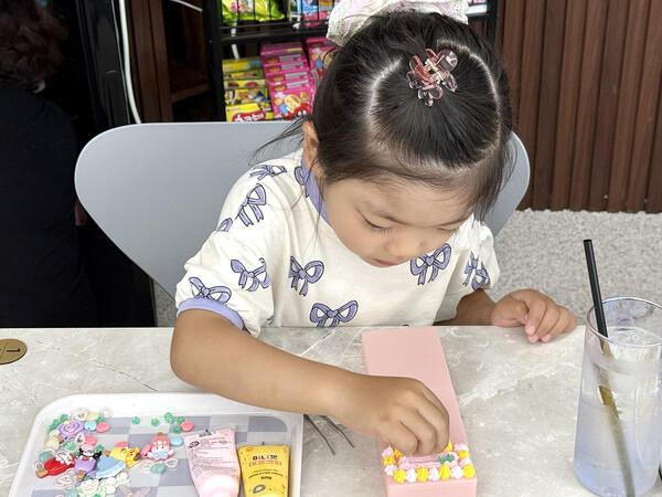 파츠로 필통꾸미기 체험을 하고 있는 아이 모습