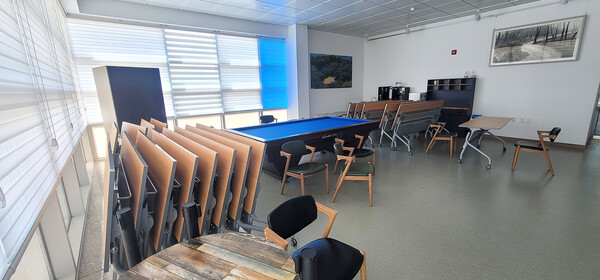 이용이 불가능한 상태로 방치된 시설 내 당구장. 내부에 책상과 의자가 가득 쌓여 있다.