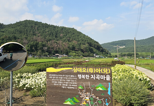 안내판 뒤 들판과 백운저수지가 보인다