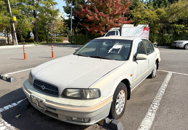 중동 장미공원에 녹이 슬고 먼지가 쌓인 장기 방치 차량 모습
